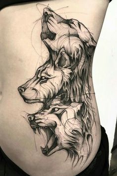 a woman's stomach with two wolf tattoos on it