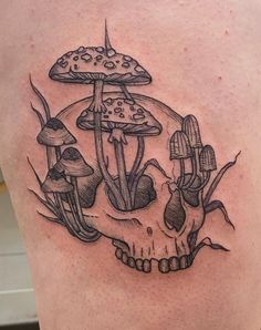 a skull with mushrooms on it's back is in the middle of a tattoo