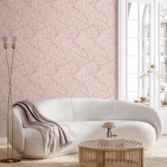 a living room with a white couch and pink wallpaper on the walls behind it