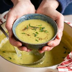 a person holding a bowl of soup in their hands