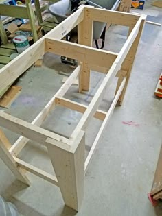 the unfinished table is ready to be built and put into place on the floor in the shop