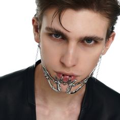 a man with chains around his neck making a face