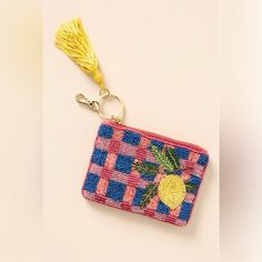 a small purse with a tassel hanging from it's side on a white surface