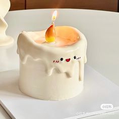 a small white candle sitting on top of a table