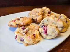 four cookies on a plate with cranberry toppings