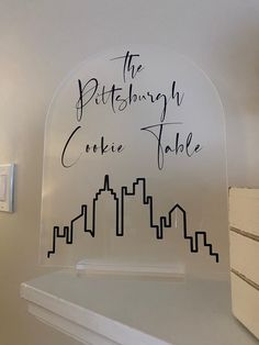 there is a sign on the wall that says the pittsburgh cookie table in black ink