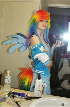 a woman with colorful hair is taking a selfie in the mirror while holding a camera