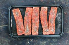 raw salmon fillets on a baking tray ready to be cooked in the oven for dinner