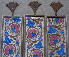 three decorative wall hangings with blue and pink flowers