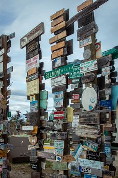 many wooden signs are stacked on top of each other in the same direction as one another