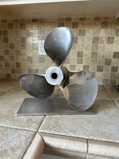 a metal propeller sitting on top of a kitchen counter next to a tile backsplash