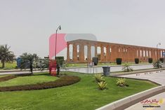 the large building has columns on it's sides and is surrounded by green grass