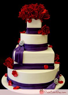 a three tiered wedding cake with purple ribbon and red roses on top is displayed