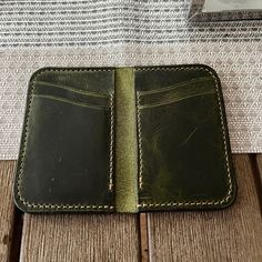 This handmade wallet is crafted from full-grain Italian vegetable-tanned pull-up leather from the Badalassi Carlo tannery in San Miniato, Tuscany. The olive green leather has a rich, earthy tone that gets deeper with age, giving it a vintage charm and distressed look. The leather also has beautiful shifts in colour. Features: - Handcrafted and handstitched for durability and charm - Made from full-grain Italian vegetable-tanned pull-up leather - Six card slots to accommodate 1-2 cards each Classic Leather Wallet, Vegetable-tanned, Green Wallets With Coin Pocket, Handmade Green Wallet For Daily Use, Vegetable-tanned Leather Wallet For Daily Use, Handmade Leather Wallets For Everyday Carry, Green Leather Wallet As Gift, Handmade Green Wallets For Everyday, Classic Vegetable-tanned Wallets For Daily Use, Vegetable-tanned Leather Wallet