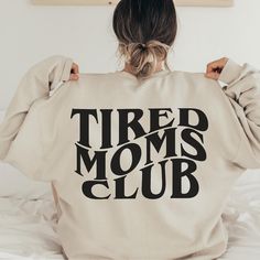 beige unisex tired moms club sweatshirt with print on the back Super Soft Cozy Sweatshirt, Super Soft Cozy Sweatshirt In Relaxed Fit, Cotton Graphic Print Tops For Lounging, Comfy Super Soft Sweatshirt For Lounging, Super Soft Sweatshirt For Fall Lounging, Graphic Print Crew Neck Top For Lounging, Comfy Super Soft Lounging Sweatshirt, Trendy Tops For Lounging In Fall, Trendy Cotton Tops For Lounging