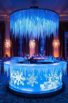 an illuminated bar with snowflakes hanging from the ceiling and chandelier above it