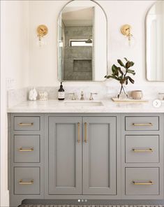 a bathroom vanity with two sinks and mirrors