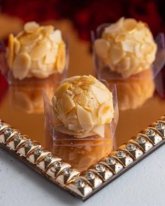 three desserts are sitting on a tray in front of a mirror with gold trim