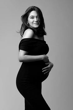 a pregnant woman poses for a black and white photo