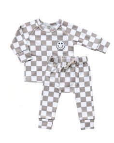 Introducing the Latte Checkered Smiley Lounge Set, your little one’s new favorite for all-day fun and comfort. This set features our beloved smiley design in a chic checkered pattern, making it a stylish addition to any child’s wardrobe. Crafted with 95% high-quality cotton and 5% spandex, it provides the perfect balance of softness and stretch, ideal for playtime, downtime, or anytime. This gender-neutral set ensures every child can enjoy the comfort and style it offers, making bundling up a jo Plaid Cotton Playtime Set, Cute Plaid Cotton Sets, Playful Plaid Sets For Spring, Cute Gingham Sets For Playtime, Cute Plaid Playtime Sets, Cute Gingham Playtime Sets, Bamboo Shop, Baby Luna, Smocked Clothes