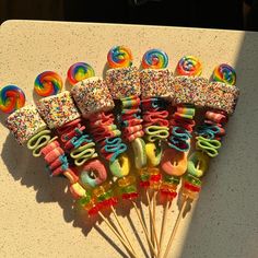 a bunch of candy lollipops on a table with sprinkles