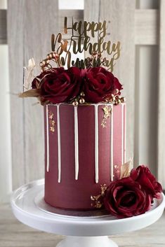 a red and gold birthday cake with roses on top