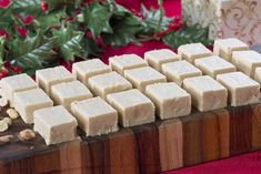 several pieces of white chocolate sitting on top of a wooden board next to christmas decorations