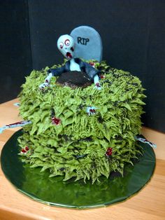 a cake made to look like it has been decorated with moss and two tombstones