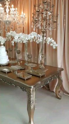 a table topped with lots of white flowers next to a wall covered in chandeliers