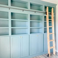 a ladder leaning against the wall next to blue bookshelves