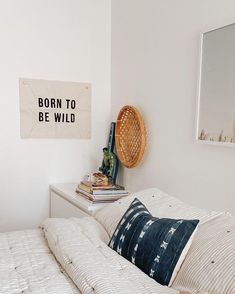 a bedroom with a bed, pillows and a sign on the wall that says born to be wild