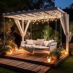 a white couch sitting on top of a wooden deck under a canopy covered in lights