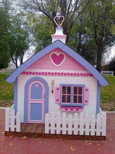 a pink and blue doll house with a heart on the roof