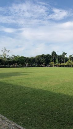 an empty soccer field with trees in the background