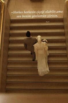 two people walking up some stairs with a clock on the wall behind them and an advertisement in spanish