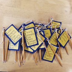 several wooden pencils with writing on them and string attached to the ends, sitting on a table