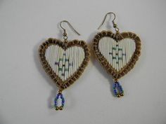 two heart shaped earrings with beaded details on them, hanging from earwires