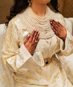 a woman in white dress holding her hands up to her chest with both hands together