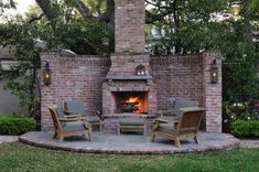 an outdoor fireplace with chairs around it