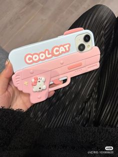 a person holding a pink and blue case with hello kitty on the side that says cool cat