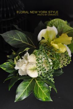 a bouquet of flowers with green leaves on a black background