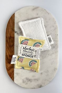 two towels on top of a marble platter next to a wooden cutting board with labels