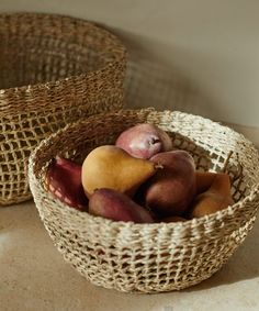 two baskets filled with fruit sitting on top of a counter