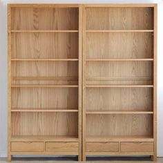 two wooden bookshelves sitting next to each other in front of a white wall