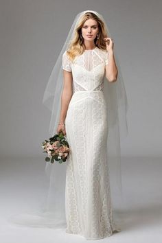 a woman in a wedding dress and veil posing for the camera with her hand on her shoulder