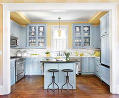 a kitchen with blue cabinets and wooden floors