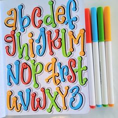 an open notebook with colorful letters and markers