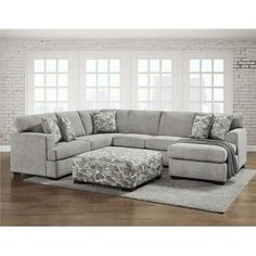 a living room with a sectional couch and ottoman