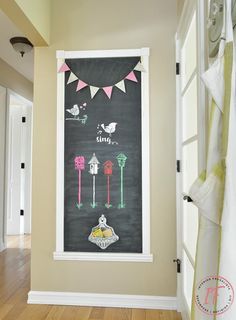 a chalkboard is hanging on the wall in front of a door with bunting