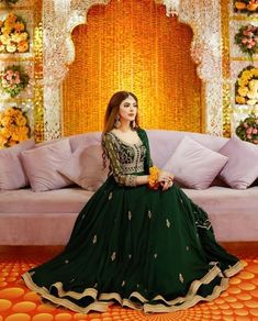 a woman sitting on a couch in front of a decorated stage with flowers and decorations